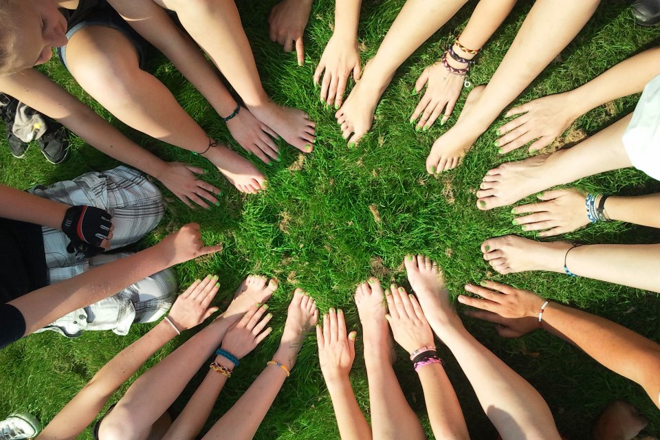 Young children putting their hands and feet in a circle